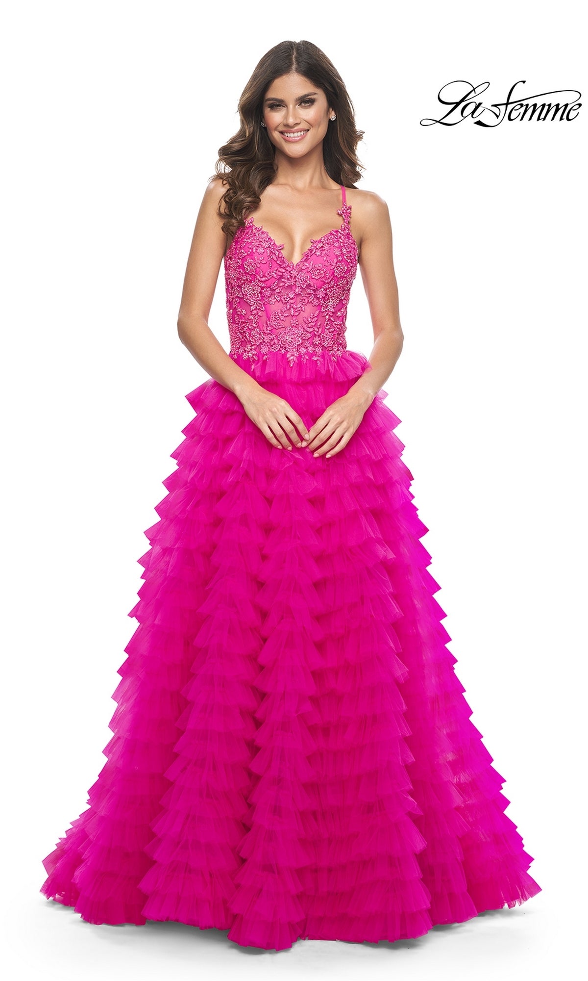 A woman smiles in the La Femme Hot Pink Long Ruffled Prom Dress 32334, featuring an embroidered-lace bodice and a ruffled a-line skirt. The La Femme logo is displayed in the top right corner.